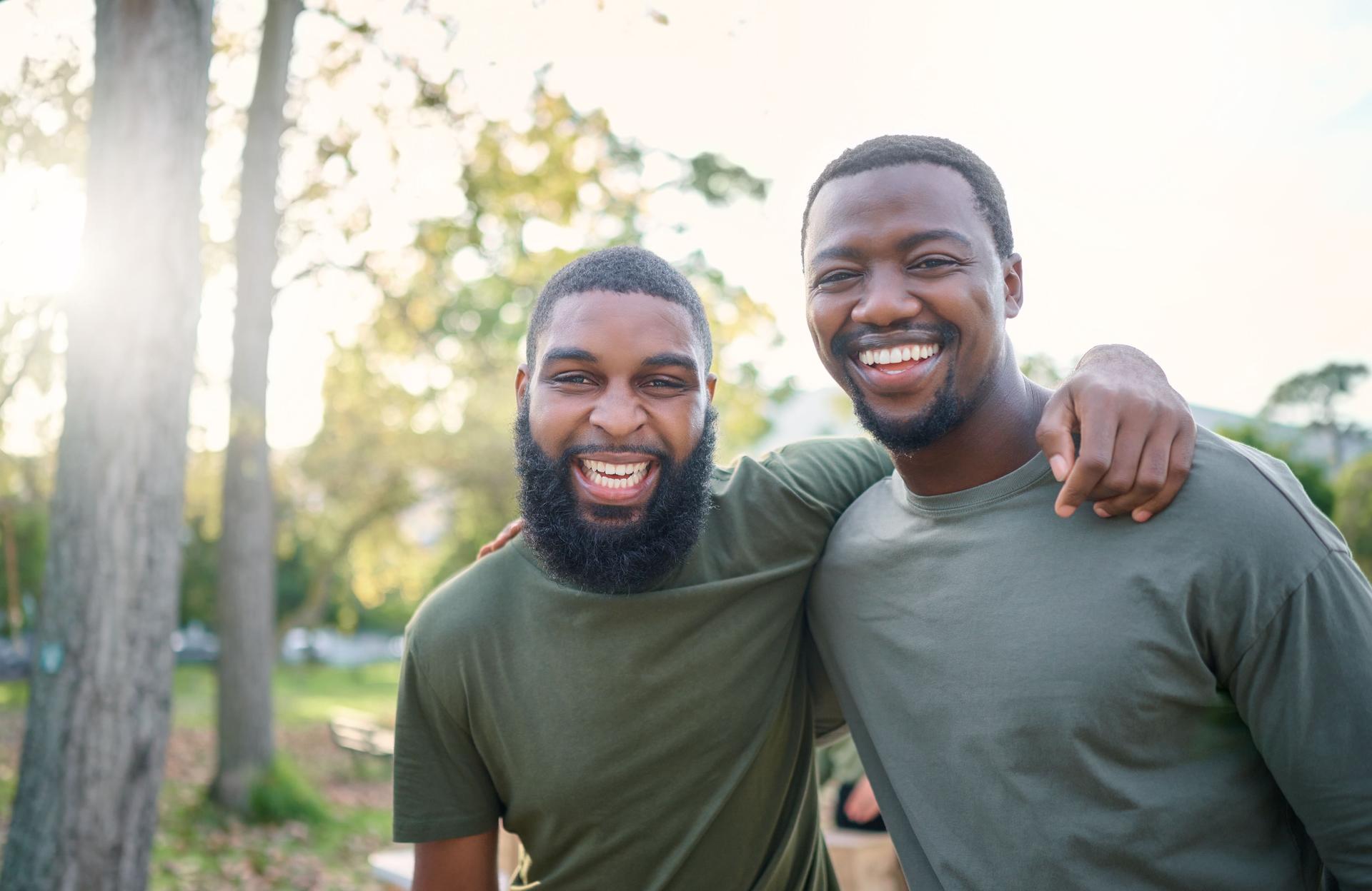 Black men, friends and happy face portrait of volunteer people outdoor at a nature park in summer. People together for community service in a green ngo tshirt for recycling and a clean enviroment