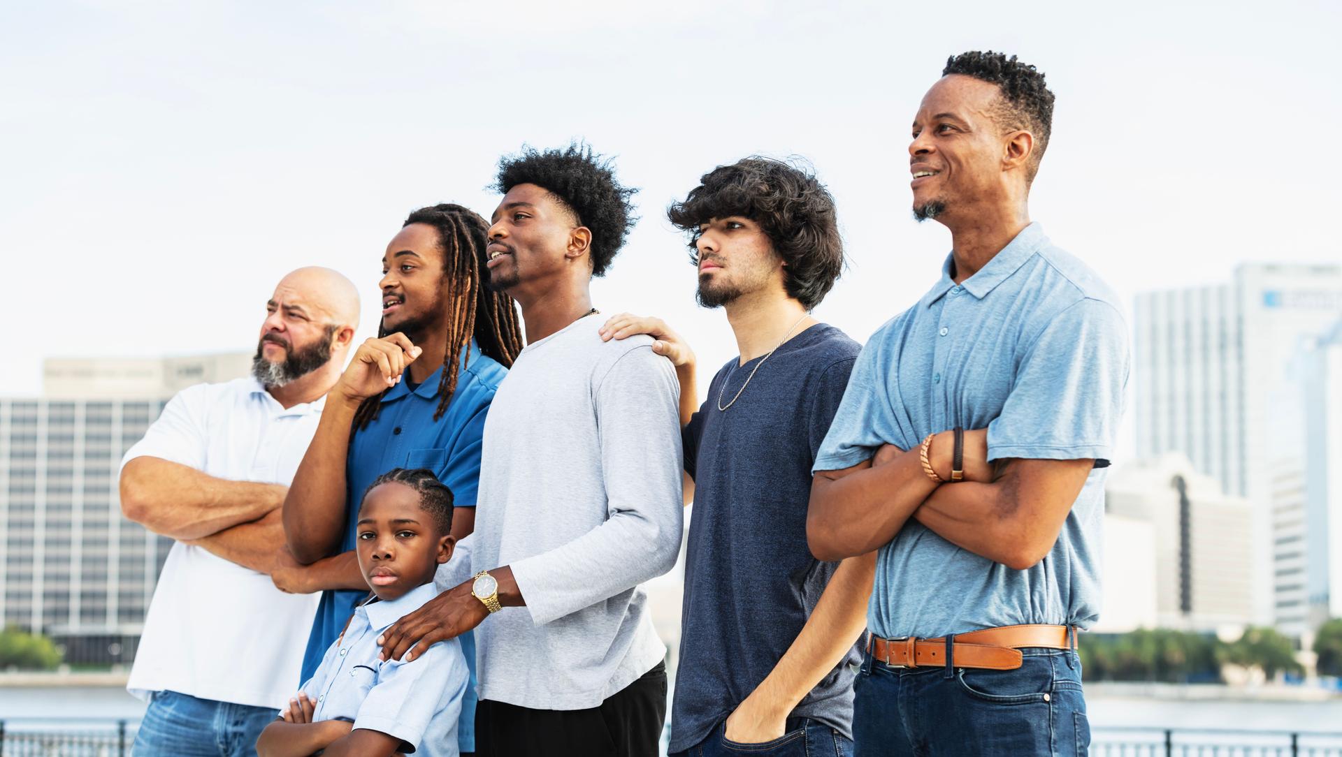 Boy standing with family and friends, looking at camera