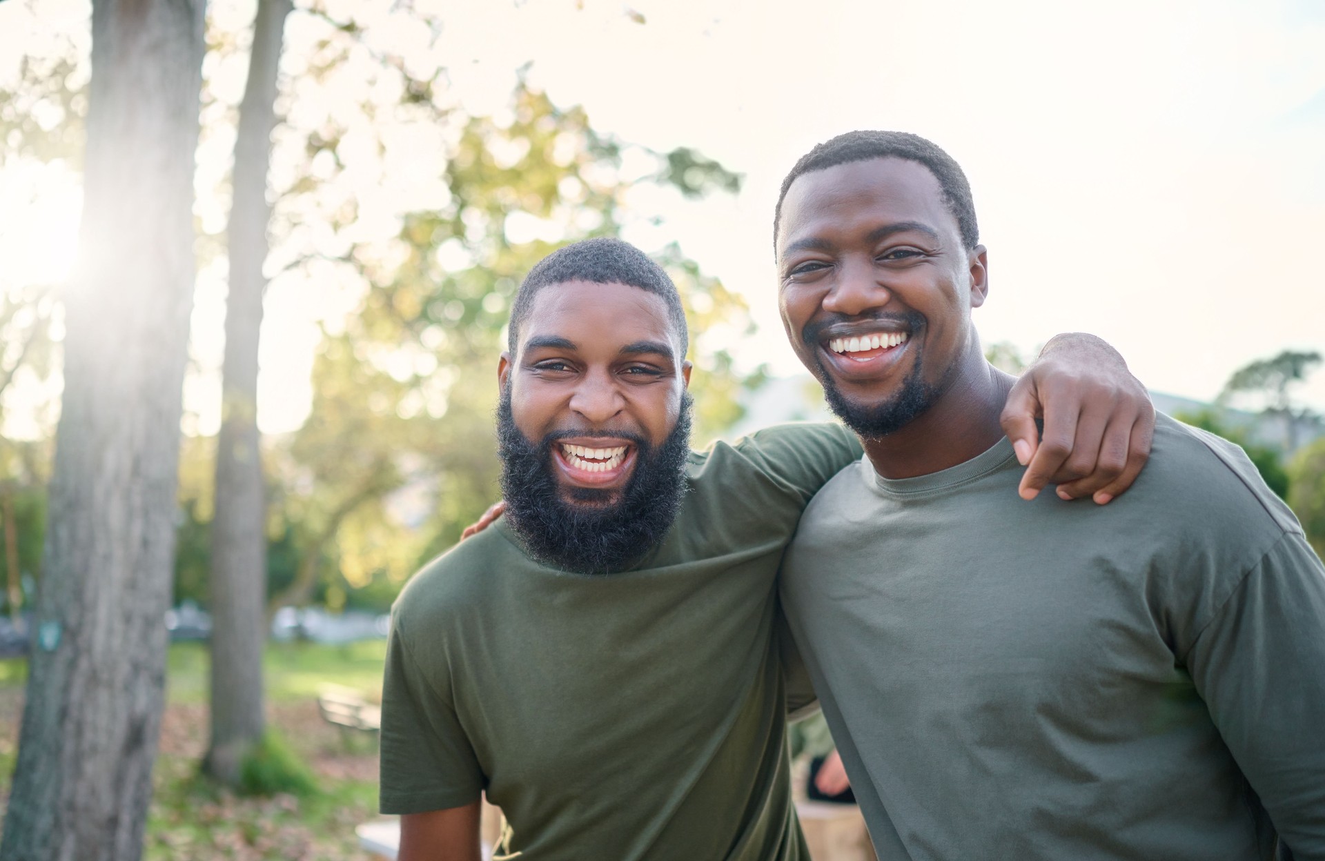 Black men, friends and happy face portrait of volunteer people outdoor at a nature park in summer. People together for community service in a green ngo tshirt for recycling and a clean enviroment