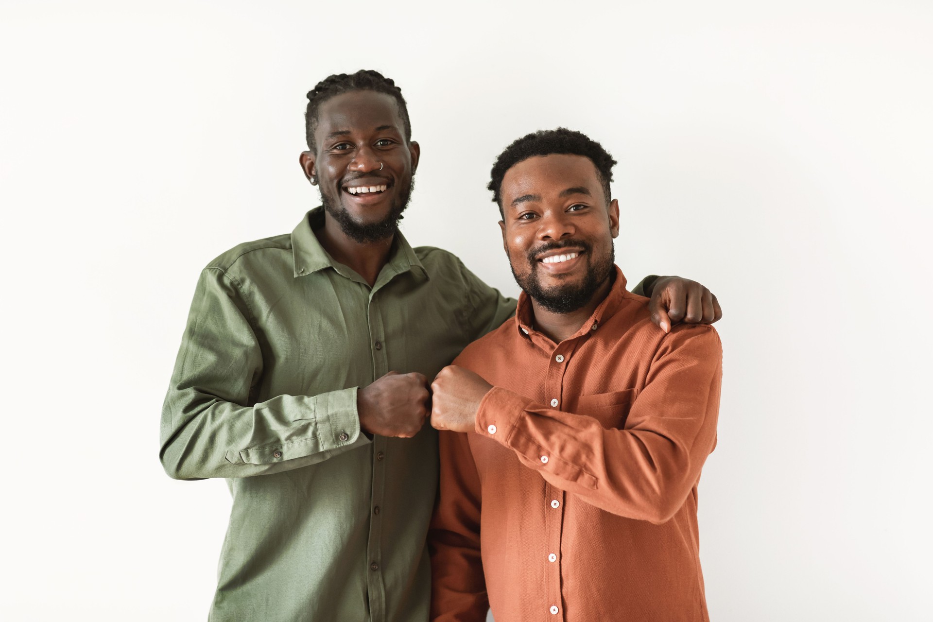Two Happy African American Guys Bumping Fists Over White Background