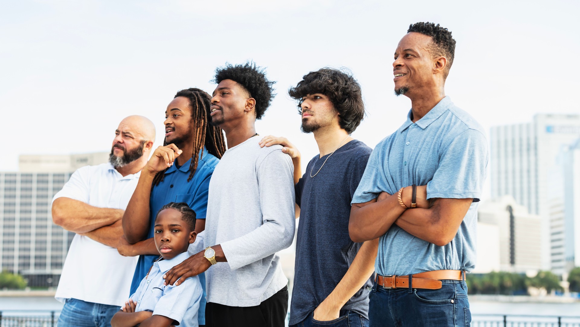 Boy standing with family and friends, looking at camera
